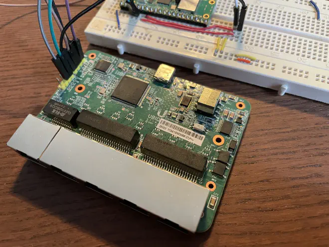 [Image of a switch PCB (the USW Flex Mini) in a slight angle. Behind is a breadbord visible with a corner of a rp pico.]